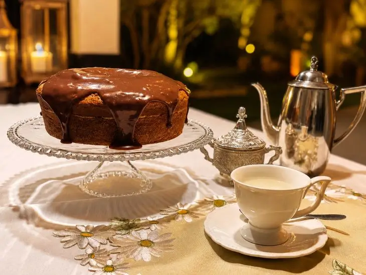 Bolo de Fubá com Calda de Brigadeiro Cremosa servido e pronto para comer, fotografado de perto sobre a mesa